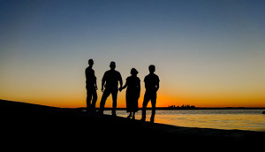 Family silhouettes at sunset on a beach