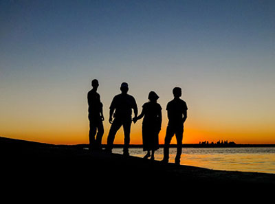 silhouette of a family on the beach at sunset