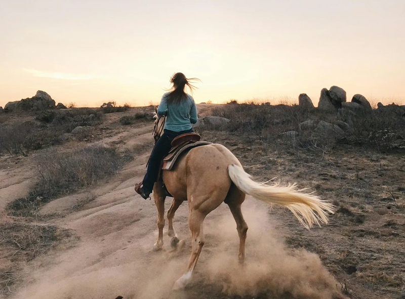 woman riding horseback through the desert - synchronicities